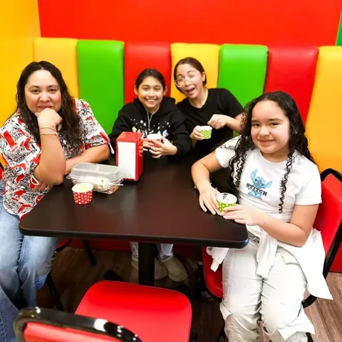 A mom and three girls sharing ice cream in the striped booths