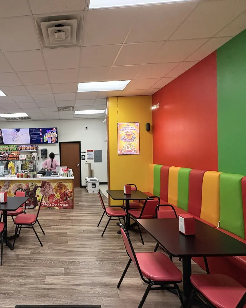 Inside Chicos: striped red, yellow and green booths, tables and the counter