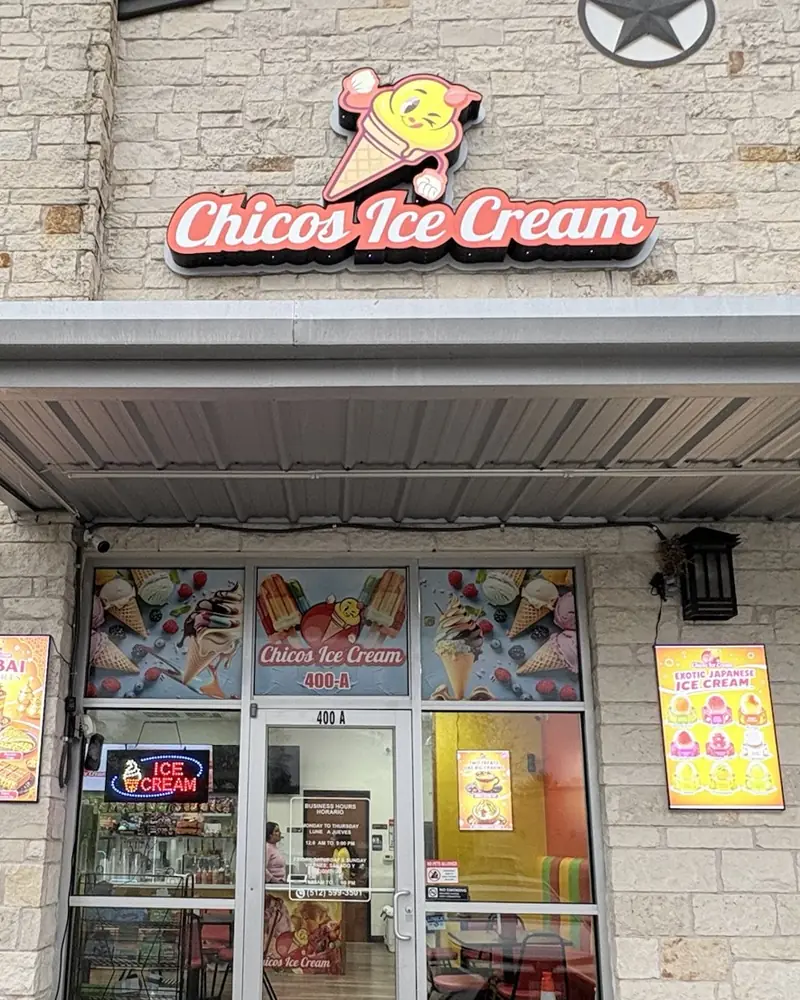 The Chicos Ice Cream storefront at Suite 400A: the winking cone sign above the glass door and the Exotic Japanese ice cream poster on the wall to the right